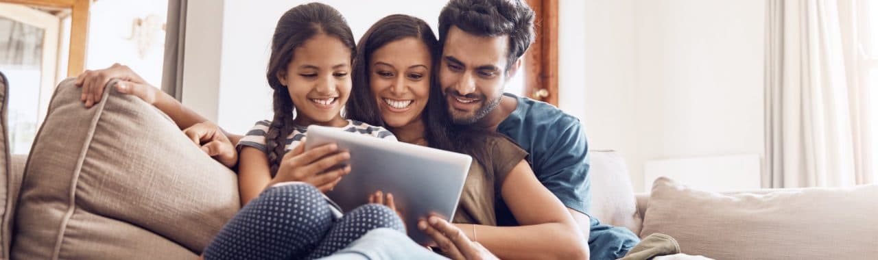 Family of three using the internet on a tablet.