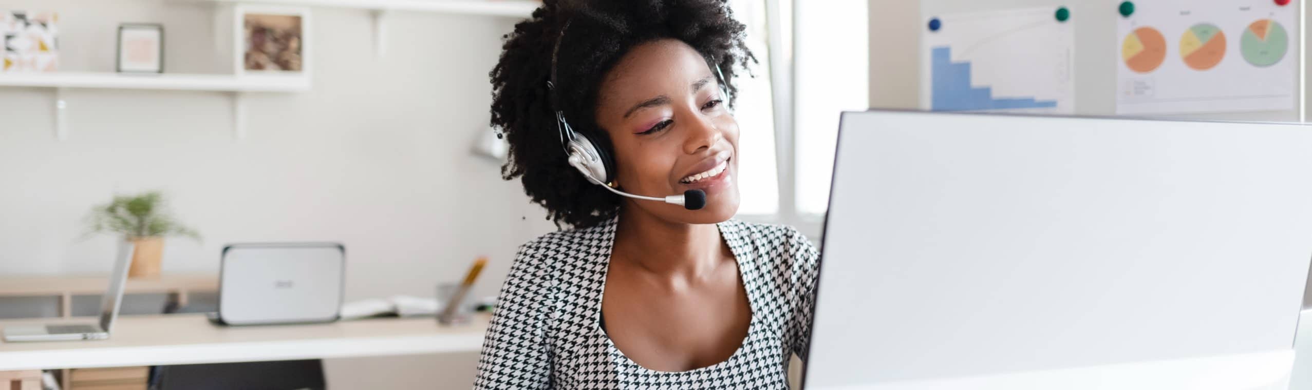 Happy woman using ToldeoTel VOIP services while working on computer.